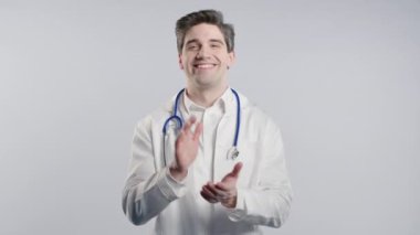 Beyaz önlüklü mutlu genç Amerikalı doktor alkışlıyor. Gülümseyen olgun tıbbi profesyonel duygusal alkış, tebrikler. Destek, tezahürat, minnettarlık konsepti. 4k