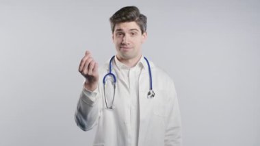 Beyaz önlüklü, yolsuzluğa bulaşmış gülümseyen bir doktor beyaz stüdyo geçmişinden para istiyor. Olgun doktor sinsice gülümser, rüşvete erişilebilir.