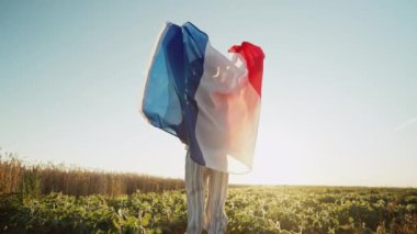 Küçük tanınmayan çocuk. Fransız vatansever çocuk. Gün batımında gökyüzünde ulusal bayrak sallayarak atlıyor. Kutlama. Banner, seçim, Fransa, iş gücü. Yüksek kalite 4k görüntü