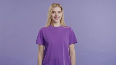 Güzel sarışın genç kız, doğal güzellik. Menekşeli genç bayan, büyüleyici yeşil gözler. Amerikan görüntüsü kameraya bakıyor. Yüksek kalite 4k