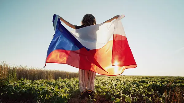 Stock image Czech little toddler son - patriot child boy jumps with national flag on nature background at summer sunset. Cestina celebration banner, holidays in Czechia. High quality