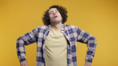 Kafa işareti olmadan onaylamayan ciddi bir adam, onaylanmayacak şekilde başını sallıyor. Reddetmek, reddetmek, anlaşmazlık, sarı arka planda genç bir adamın portresi. Yüksek kalite 4k görüntü