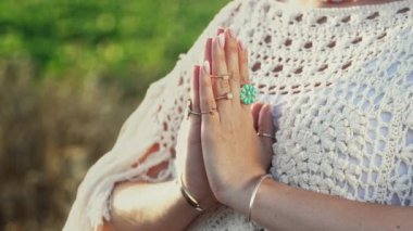 Yeşil arka planda dua eden, meditasyon yapan, mantraları okuyan düşünceleri, istekleri ya da evrene şükranlarını ileten bir kadın. Ruhanilik, din, Tanrı kavramı. Yüksek kalite 4k görüntü