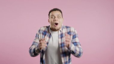 Şok adam sevindi, çığlık attı. İlgi çekmeye çalışan etkileyici bir adam. Satış konsepti, karlı bir teklif. Pembe arka planda heyecanlı bir mutluluk. Yüksek kalite 4k