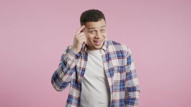 Yakışıklı afro-amerikan zeki adam jesti - sen, bir düşün. Pembe kameraya bakıyorum. Olumlu düşünüyorum. Kıvırcık esmer saçlı, zeki biri. Yüksek kalite 4k görüntü