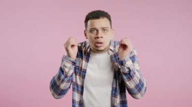 Afro-Amerikalı genç adam gözlerini ovuşturuyor. Akranları pembe ışıkta kameraya daha yakından gülümsüyor. İnanılmaz bir haber. Yüksek kalite 4k görüntü