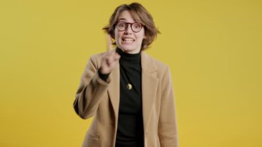 30 'ların güzel iş kadını parmaklarını dudaklarında tutuyor, sarı stüdyo geçmişi var. Şşş, sır, sessizlik, komplo, dedikodu, söylenti konsepti olan oldukça zeki bir kadın. Yüksek kalite 4k