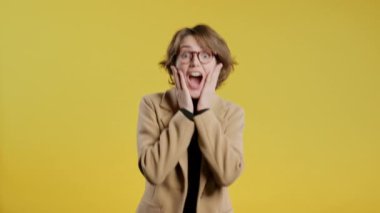 Şaşkın İş Kadını, vay canına diyor, inanamıyorum. İlgi çekmeye çalışan etkileyici bir bayan. Satış kavramı, karlı bir teklif. Sarı arka planda heyecanlı öğrenci kız. Yüksek kalite 4k