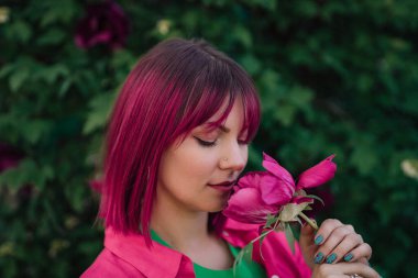 Pembe fuşya rengine boyanmış gerçek dingin bir kadının portresi. Renkli saçlar, şık saç kesimi. Mutlu alışılmadık kız, sanat yaşam tarzı.