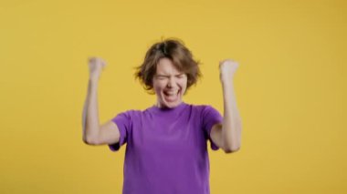 30 'lu yılların güzel kadınları zaferlerini gösteriyor. Evet, zafer jestleri, başarılar, hedefler. Zarif bayan mutlu, mutlu, şaşırmış sarı arka planda heyecanlı mutlu bayan. Büyük ikramiye konsepti. Yüksek kalite 4k