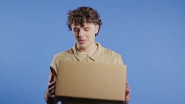 Heyecanlı gülümseyen adam, çevrimiçi alışveriş tüketicisi karton sipariş paketi aldı, istenilen satın alma. Ev kuryesi teslimat servisi. İndirim, indirim. Yüksek kalite 4k görüntü