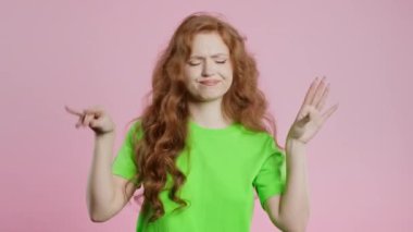 Sinirli 20 'li yaşlarda bir kadın pembe arka planda elleri olan bir jest yapıyor. Boş vaatler, ironi, falan filan. Yalancı! Yüksek kalite 4k