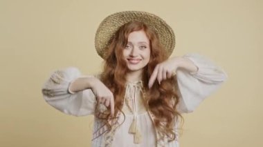 Kızıl saçlı kadın reklam alanını işaret ediyor. bej arka plan. Blog yazarı aşağıdaki aboneliğe tıklamak istiyor. Ticari fikrin için yer kopyala, promosyon içeriği. Yüksek kalite 4k