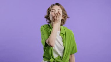 Çekici, çekici, şık saç stili olan Amerikalı genç bayan menekşe duvar arka planında kameraya hava öpücüğü yolluyor. Sevimli moda bayan portresi.