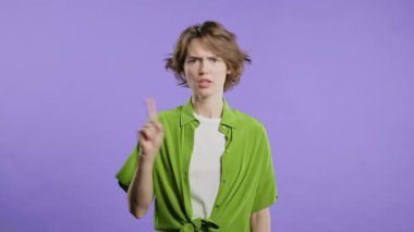 Dur işaretini tasvip etmeyen stil sahibi bir kadın. Benimle oynama, bu kadar yeter. Menekşe arka planda bayan portresi. Yüksek kalite 4k