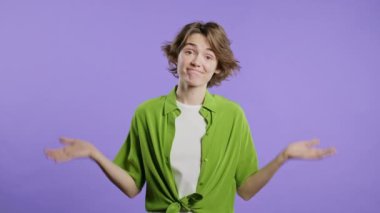 30 'lu yaşlarda kafası karışık bir kadın, omuzları kalkık. Yardımcı olamıyor. Bilmiyorum. Zor bir soru, suçlu tepkisi, mor arka planda şaşkın stil sahibi bir kadın. Yüksek kalite 4k