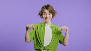 Reklam alanına bakan kısa saçlı kadın. Menekşe arkaplan. Blog yazarı aşağıdaki aboneliğe tıklamak istiyor. Ticari fikrin için yer kopyala, promosyon içeriği. Yüksek kalite 4k