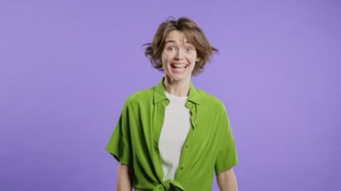 Dost canlısı genç kız evet işareti veriyor, başını sallıyor, onaylıyor. Olumlu gülümseyen Avrupalı kadın, vücut dili. Doğru mükemmel seçim, harika bir anlaşma. Violet stüdyo geçmişi. 4k