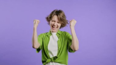 30 'lu yılların güzel kadınları zaferlerini gösteriyor. Evet, zafer jestleri, başarılar, hedefler. Zarif bayan mutlu, mutlu, şaşırmış menekşe arka planda heyecanlı mutlu bayan. Büyük ikramiye konsepti. Yüksek kalite 4k