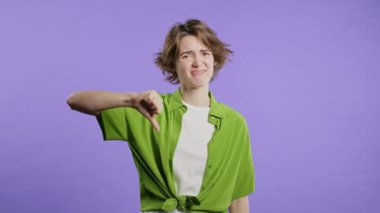 Mutsuz Avrupalı kadın portresi, hoşlanmama ve utandırma işaretiyle kınanıyor. Genç milenyum hanımefendisi Violet stüdyosunun arka planında olumsuz jest göstererek memnuniyetsizliğini dile getiriyor..