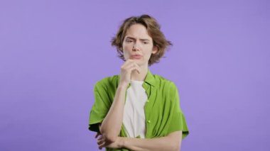 Mutlu bir kadın menekşe arkaplanını işaret ederek 