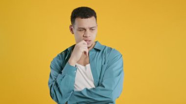 Hipster, Afro-Amerikan, sarı üzerine kafa yoruyor. Kafası karışmış öğrenci cevabı bulmaya çalışıyor ya da ne unuttuğunu hatırlamaya çalışıyor, hafıza konsepti. Yüksek kalite 4k