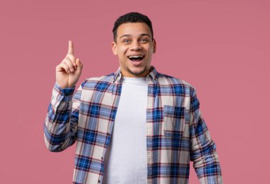 Zeki genç bir adamın fikir üretme anı, pembe arka planı işaret ediyor. Afro-Amerikalı öğrenci cevap veriyor ya da ne unuttuğunu hatırlıyor, hafıza konsepti..