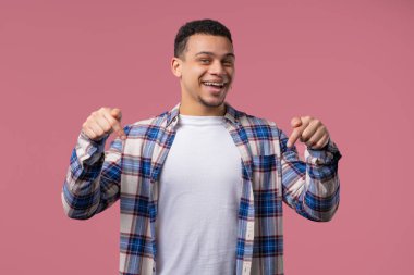 Öğrenci adam reklam alanını işaret ediyor. Pembe arka plan. Blog yazarı aşağıdaki aboneliğe tıklamak istiyor. Ticari fikrin için yer kopyala, promosyon içeriği. Yüksek kalite