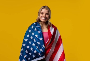 Proud Smiling Adult Woman With National Usa Flag On Yellow Background. American patriot, US banner. Symbol of democracy, independence, future. High quality photo clipart