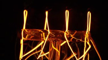 Makro, yanıp sönen Edison Tungsten filament lambası, titreyen klasik retro ampul detaylarını anlattı. Enerji, elektrik, yenilik. Elektrik gücü. Yüksek kalite 4k görüntü
