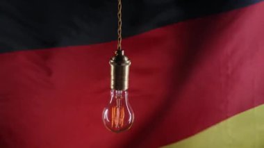 Alman bayraklı arka planda Edison ampulü yanıp sönüyor. Kötü elektrik tedariği, problemler, Almanya 'daki enerji krizi, Deutschland. Yüksek kalite 4k görüntü