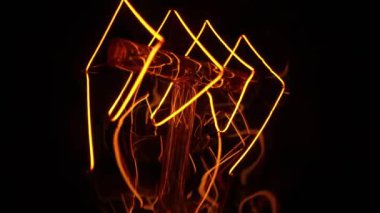 Makro, yanıp sönen Edison Tungsten filament lambası, titreyen klasik retro ampul detaylarını anlattı. Enerji, elektrik, yenilik. Elektrik gücü. Yüksek kalite 4k