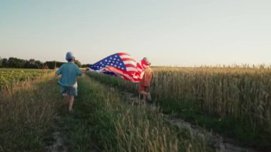 Sevimli küçük çocuklar - Amerikan vatansever çocuklar açık arazi yolunda ulusal bayrak sallayarak koşuyorlar. ABD, 4 Temmuz - Bağımsızlık Günü, Kutlama. Amerikan bayrağı, gaziler, seçimler. Yüksek kalite 4 bin.