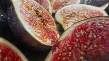 Kamera dilimlenmiş yarımlar, sağlıklı sulu incirler arasında hareket eder. Dolly Slider ekstrem makro. Mevsimlik meyve ayrıntıları, yakın çekim tohumları, Ficus carica dokusu. Yüksek kalite 4k görüntü