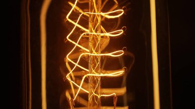 Makro, yanıp sönen Edison Tungsten filament lambası, titreyen klasik retro ampul detaylarını anlattı. Enerji, elektrik, yenilik. Elektrik gücü. Yüksek kalite