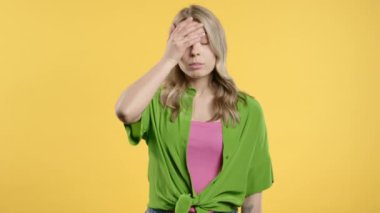 Kafası karışmış genç Amerikalı kız, hayır, unuttu. Üzüntü, pişmanlık, drama, başarısızlık, sarı arka planda sorunlar hisseden bir kadın. Yüz bakımı. Yüksek kalite 4k