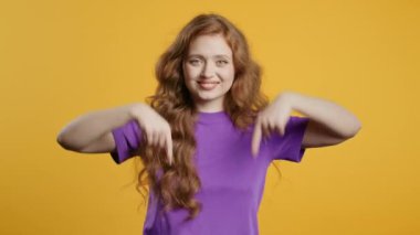 Kızıl saçlı kadın reklam alanını işaret ediyor. Sarı arka plan. Blog yazarı aşağıdaki aboneliğe tıklamak istiyor. Ticari fikrin için yer kopyala, promosyon içeriği. Yüksek kalite 4k