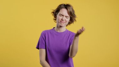 Kafası karışmış genç Amerikalı kız, hayır, unuttu. Üzüntü, pişmanlık, drama, başarısızlık, sarı arka planda sorunlar hisseden bir kadın. Yüz bakımı. Yüksek kalite 4k