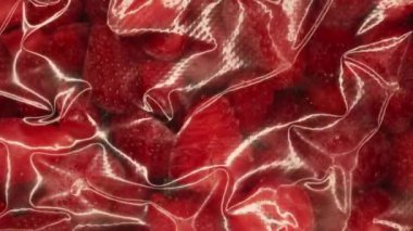 Paketleme cihazı vakumluyor, plastik torbadan taze organik çilek dilimleri ile hava çıkarıyor. Dondurucu deposu hazırlığı. Yüksek kalite 4k görüntü