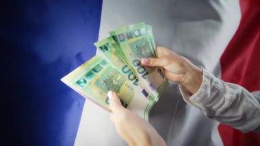 Fransız bayrağı geçmişi. Avro sayan bir kadın. Kredi, AB Avrupa 'da gümrük vergilerinin artırılması, seyahat masrafları, finansal konsept. Yüksek kalite 4k görüntü