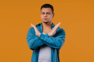 Ciddi şekilde hoşnutsuz, hiçbir işaret olmadan onaylamayan, reddeden, onaylanmayacak şekilde başını sallayan bir adam. Reddetmek, reddetmek, anlaşmazlık, Yellow 'daki gencin portresi, olumsuz cevap. Yüksek kalite 