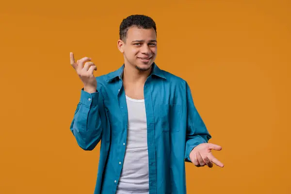 Stock image Mocking man pointing at camera and showing what gesture. Asking are you crazy. Quarreling isolated on yellow background. Blaming hater