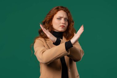 Hayır, asla, güzel, kızıl öğrenci bir kadın el işaretini keserek jestten hoşlanmaz ve reddeder. Onaylamayan ciddi bir kız olumsuzluk işareti yapıyor.