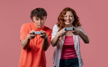 Oyuncuların çifti kumanda panelinde joysticklerle oyun oynuyor, kadın kazanıyor. Tuşlara basar, joypad kumandası kullanır, en yeni kablosuz oyun platformu. Hobi, e-spor. 