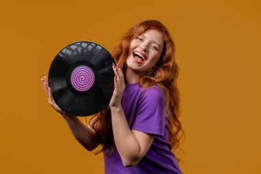 Sarıda plak CD 'siyle dans eden güzel bir kadın. Hobi, müzik aşığı, koleksiyon, nostalji yaşam tarzı. Yüksek kalite 
