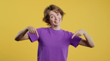 Reklam alanına bakan genç bir kadın. Sarı arka plan. Blog yazarı aşağıdaki aboneliğe tıklamak istiyor. Ticari fikrin için yer kopyala, promosyon içeriği. Yüksek kalite 4k