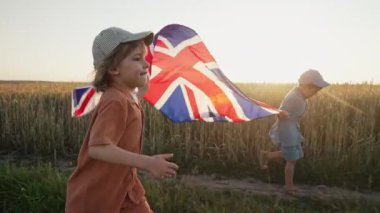 İngiliz Vatansever Çocuklar Kırsal Yol 'da Ulusal Bayrak Koşuyor. Küçük çocuklar. Demokrasinin sembolü, Büyük Britanya, gelecekteki kutlamalar, İngiltere bayrağı, Anma Günü, seçim. Çak bakalım.