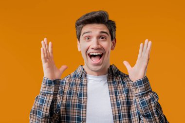 Beyaz, yakışıklı, şok olmuş adam sevindi. Çığlık attı. İlgi çekmeye çalışan etkileyici bir adam. Yaz indirimi kavramı, karlı bir teklif. Sarı arka planda heyecanlı bir mutluluk. Yüksek kalite