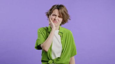 Violet stüdyo geçmişinde diş ağrısı olan güzel bir genç kız. Diş ağrısı, diş sorunları, diş hekimliği ve tıp konsepti