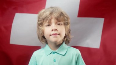 İsviçre Ulusal Bayrağı Altında Mutlu İsviçre Küçük Vatansever Çocuğu. Demokrasinin, bağımsızlığın, AB 'nin geleceğinin sembolü. afiş, çocuk günü, seçim, Avrupa, futbol.